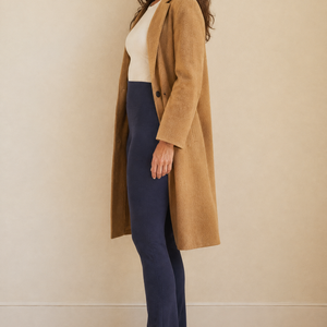 Zijaanzicht van de Matilde gevoerde legging in marineblauw met een camelkleurige jas